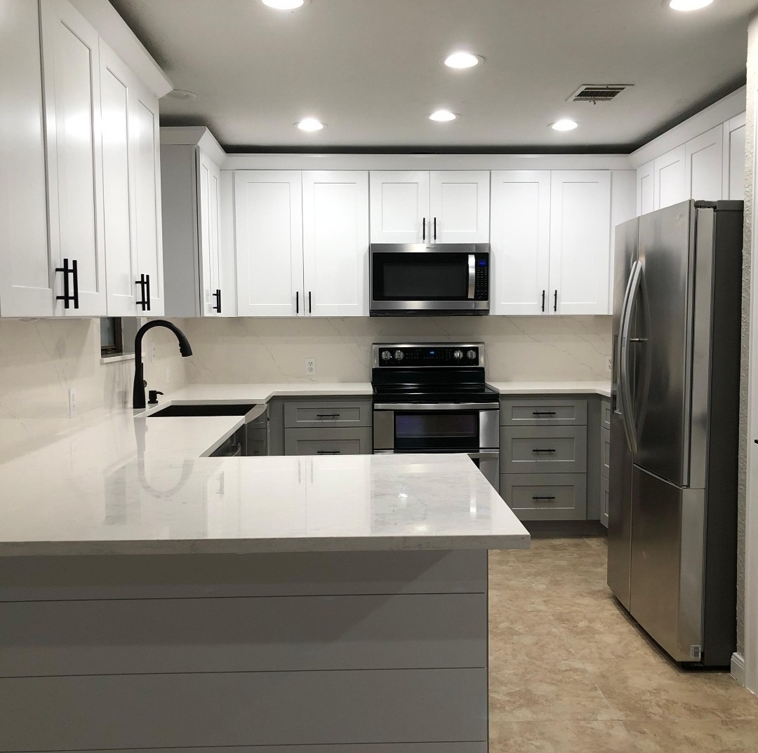 Stunning Modern Kitchen Renovation in Seattle with White Tabletops, Cabinets, and Brown Marble Flooring - Contemporary Home Remodeling by Seattle General Contracting Experts.